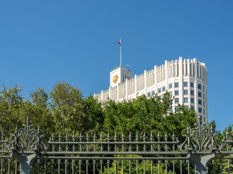 House of the Government of Russian Federation (White House). Bottom view of Russian Government House with flag. Famous state building against clear blue sky. Moscow, Russia.