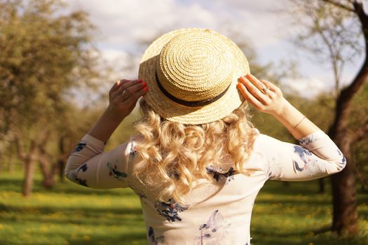 Girl in a straw hat. Back view. Trendy casual summer or spring outfit