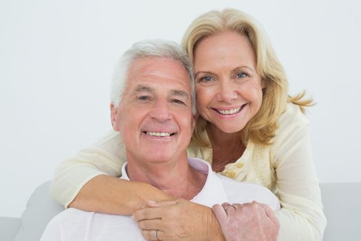 Happy senior woman embracing man from behind