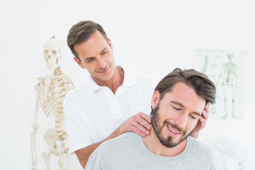Male chiropractor doing neck adjustment