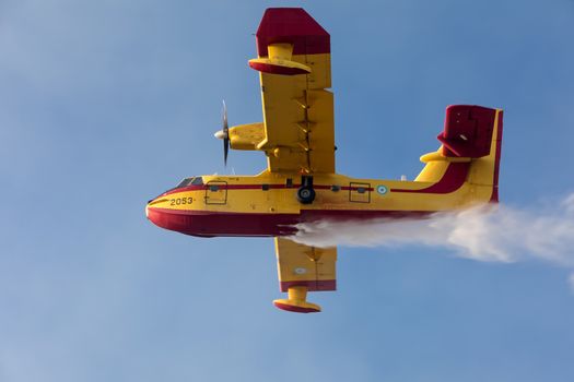 A firefighting aircraft releases the load of water as it tries t