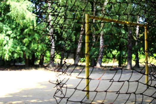 Sports field through a fence from a galvanized grid