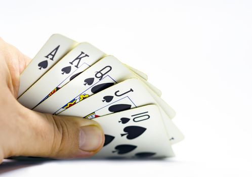 a gambler reveals a royal flush in spades. Gambling and luck.