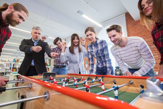 Business people playing table football
