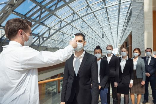Doctor check body temperature of business team