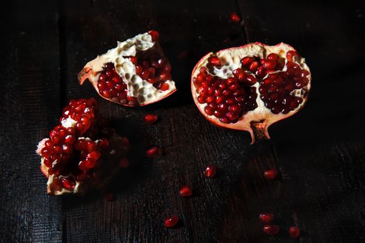 Broken pomegranate fruit on a dark background. close-up. view from above