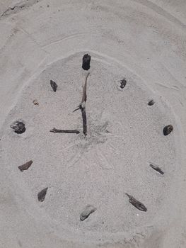 Sand and stick beach clock face 9 o clock