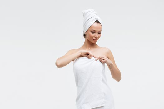 Charming woman with white towel on head straightening fingernail