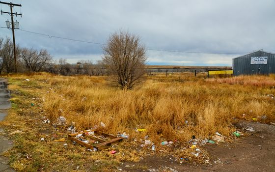 Trash on the side of a road near a desert settlement