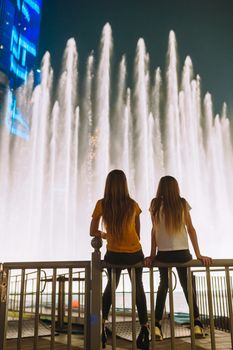 Little girls watch the legendary show of singing fountains in Dubai