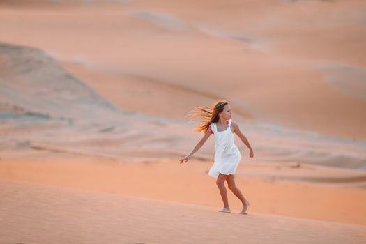 Girl among dunes in desert in United Arab Emirates