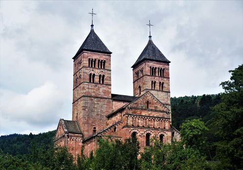 Steeples of Murbach Abbey looming out of the forest in the Vosges