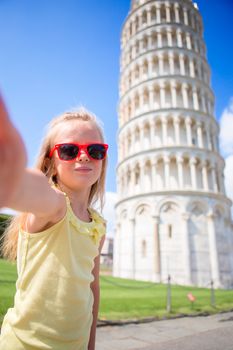 Little girl taking selfie background the Leaning Tower in Pisa, Italy