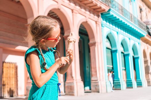Adorable little girl eating ice-cream in popular area in Old Havana, Cuba.
