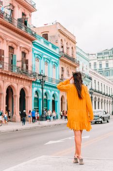 Tourist girl in popular area in Havana, Cuba. Back view of young woman traveler smiling