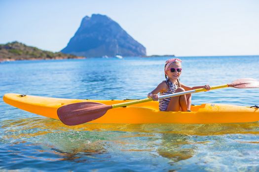 Little brave cute girl kayaking in the clear blue sea