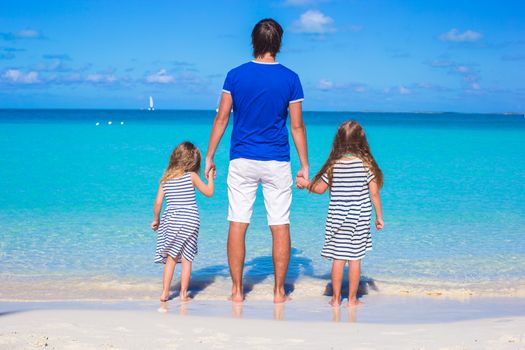 Father and his two kids walking by the sea