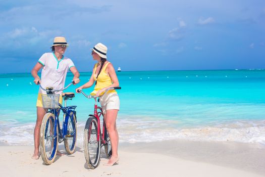 Young happy couple riding bikes during tropical vacation