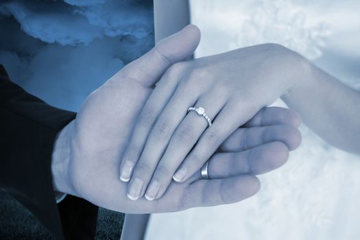 Composite image of cropped image of newly wed couple holding hands
