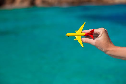 Small homemade plane in hand on background of the sea