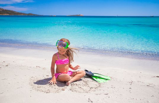 Little girl with flippers and goggles for snorkling