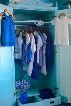 Dressing closet with blue clothes in the closet