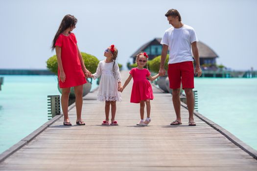 Beautiful family have fun on wooden jetty during summer vacation