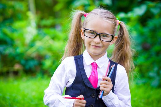 Little happy girl with pencils going back to school outdoor