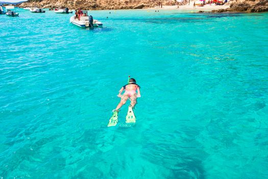 Young active girl snorkeling in tropical water on vacation
