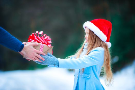 Christmas concept. Little girl giving a New Year's gift on Xmas eve