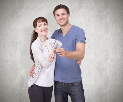 Composite image of couple holding fan of cash