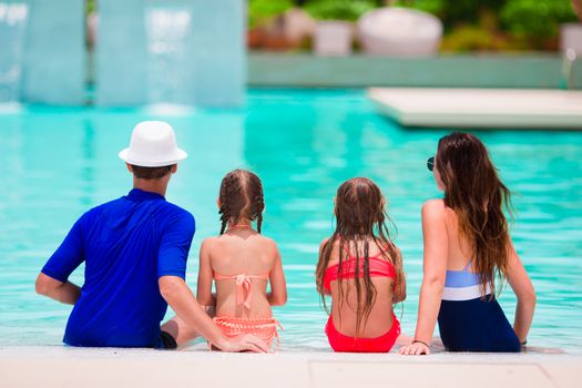 Happy family with two kids in swimming pool.