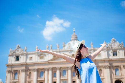 Young female tourist looking at St. Peter's Basilica church in Vatican city, Rome, Italy.