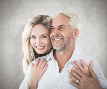 Composite image of smiling couple embracing with woman looking at camera