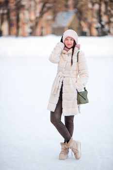Happy young woman on ice rink outdoors