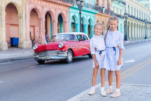 Adorable little girls in popular area in Old Havana, Cuba. Portrait of two kids outdoors on a street of Havana