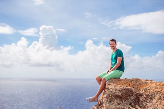 Young man enjoying breathtaking views from Shirley Heights on Antigua island in Caribbean