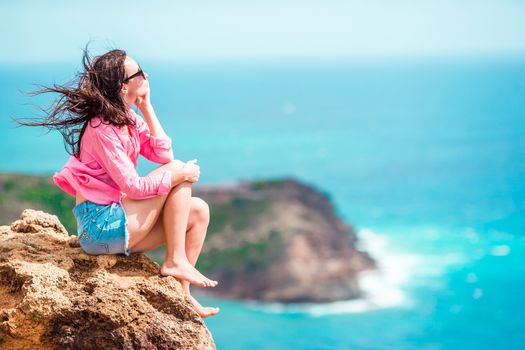 Young woman enjoying breathtaking views from Shirley Heights on Antigua island in Caribbean