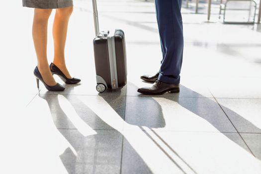 Cropped image of businessman and businesswoman standing in airport