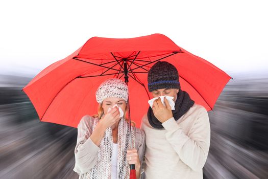 Composite image of couple in winter fashion sneezing under umbrella