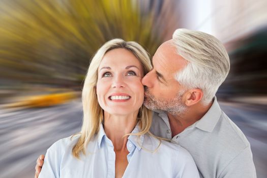 Composite image of affectionate man kissing his wife on the cheek 