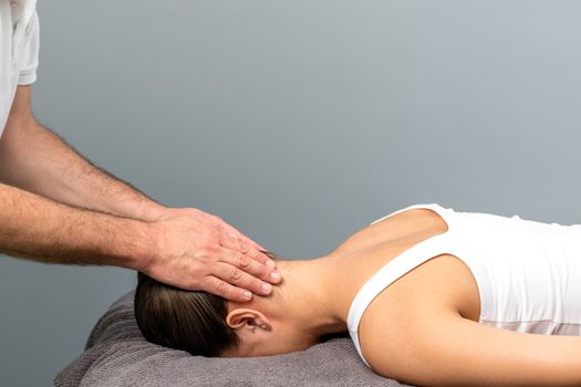 Therapist applying pressure on back of female head.