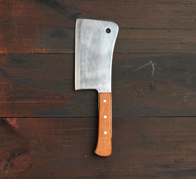 large kitchen knife for cutting meat and vegetables on a brown w