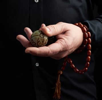 adult man in black clothes holds in his hands a stone magic ball