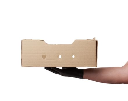 male hand in a black latex glove holds an empty brown cardboard 