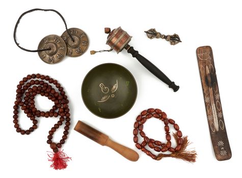 copper singing bowl, rosary, prayer drum, punitive, incense stand and wooden clapper. Set for prayers and meditations is isolated on a white background, top view