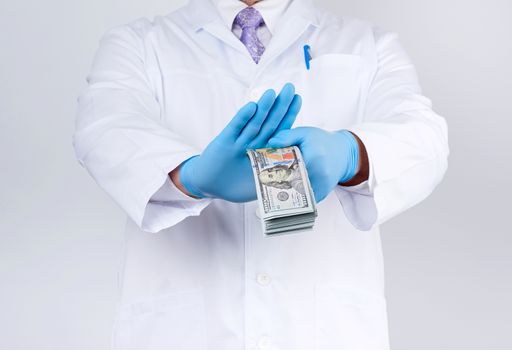 doctor holds a pack of paper money and refuses to take a bribe