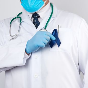 doctor in white uniform and sterile latex gloves holds a dark bl