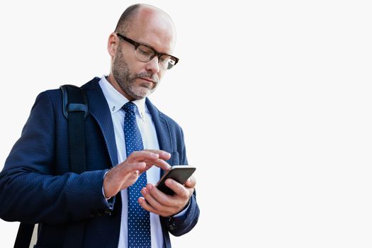 Cutout of businessman using smartphone while leaning on wall