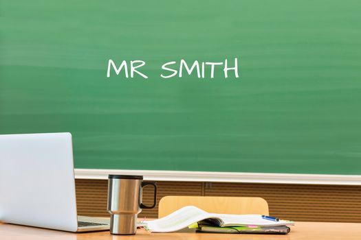 Photo of professor desk in classroom with Miss Simpson name written in black board